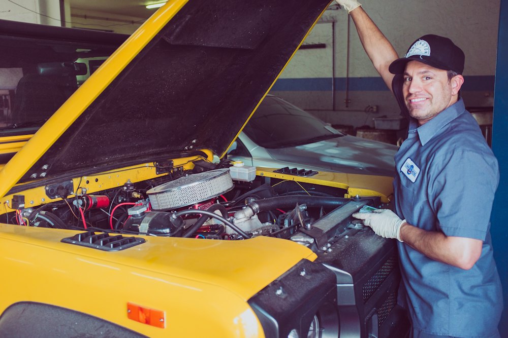 Mechanic working on a car with the bonnet open